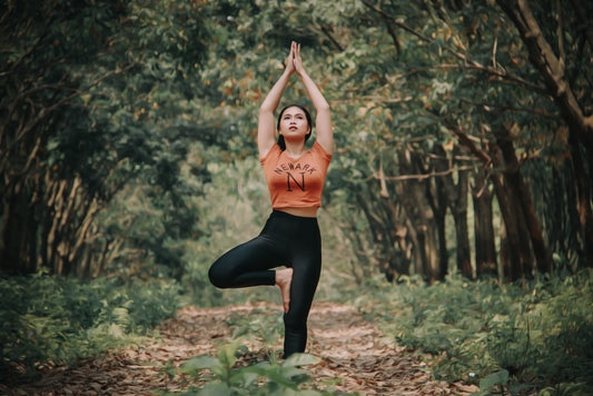 Woman wearing high-waisted yoga pants and a short T-shirt while working out