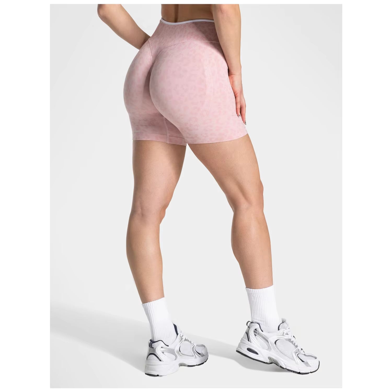 Person wearing pink athletic shorts on a white background