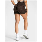 Person wearing brown leopard print shorts on a white background