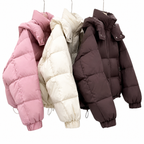 Three puffer jackets hanging side by side on a white background: one dusty pink, one cream, and one dark brown.